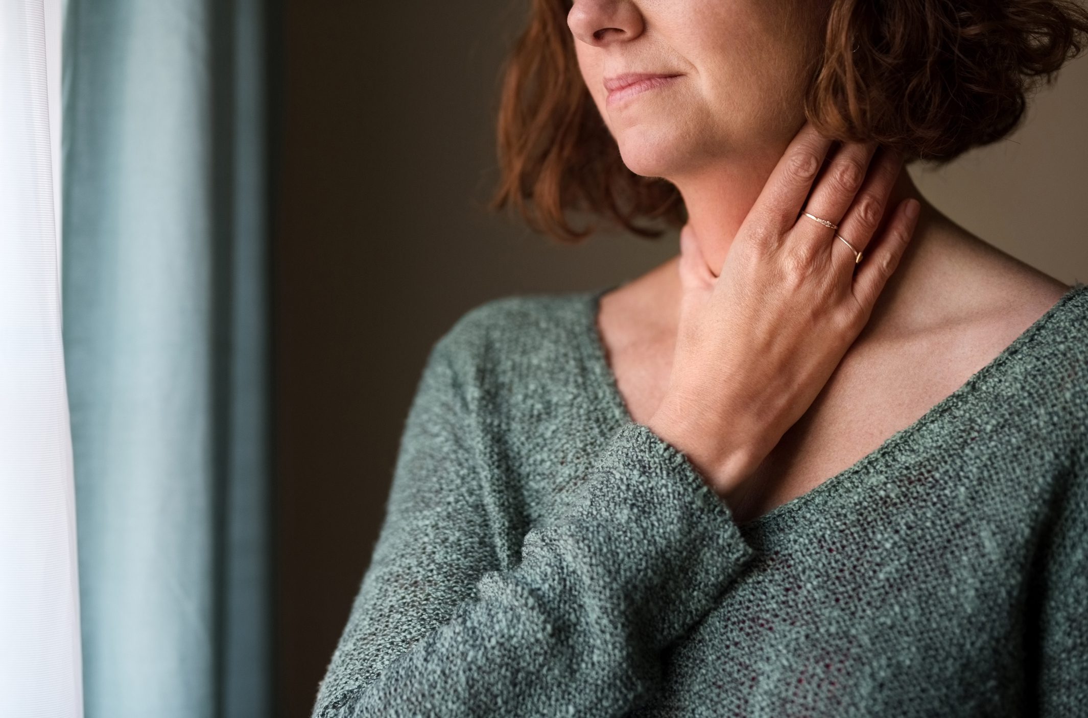 Woman holds her painful throat