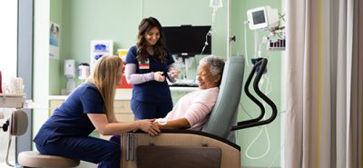 Two nurses check on an older woman undergoing chemotherapy at the St. Elizabeth Healthcare Cancer Center.