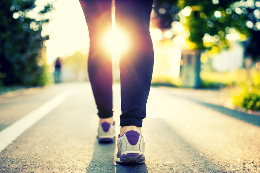 woman athlete feet and shoes while running in park.