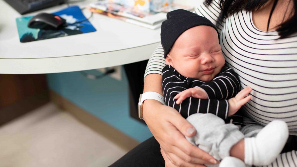 Newborn sleeping while being held.