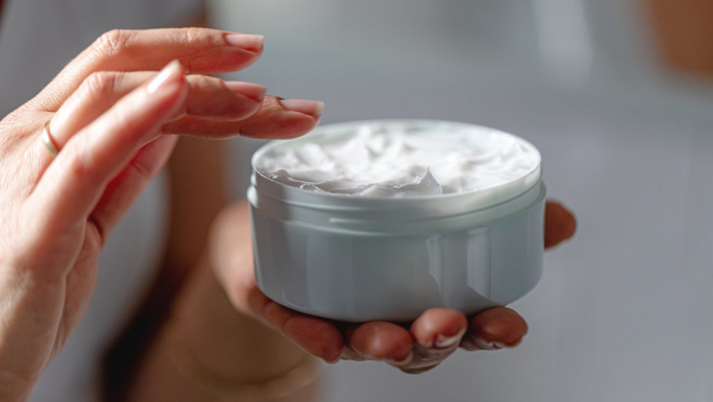 Woman using moisturizing cream for clean and soft skin