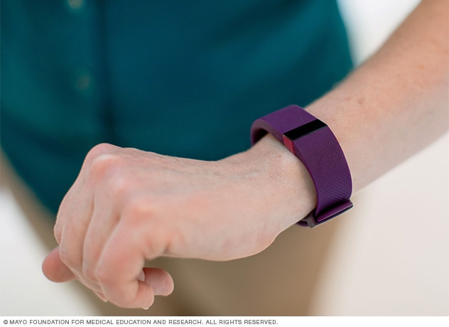 Person wearing an activity tracker on the wrist.